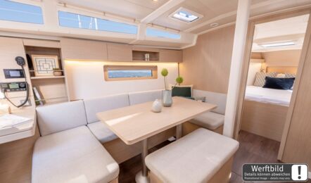 Großer Salontisch mit umlaufenden Sitzgelegenheiten im hellen Salon einer Oceanis 37.1 (Werftbild) – Yachtcharter Ostsee