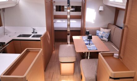 Blick in den Salon der Segelyacht Sun Odyssey 440 „Cassiopeia“ mit hellen Sitzpolstern und heller Holzoptik – Yachtcharter Ostsee