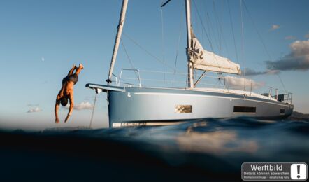 Eine Oceanis 47 vor Anker am Abend, während ein Mann vom Bug ins Wasser springt (Werftbild) – Yachtcharter Kroatien