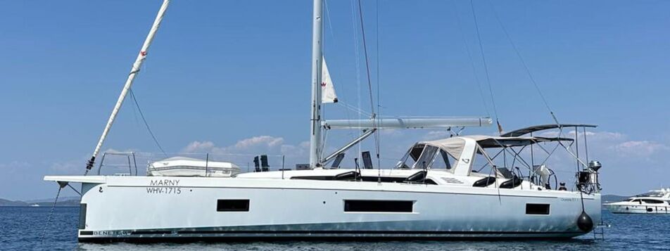 Backbordansicht der Segelyacht Oceanis 51.1.3 „Marny“ vor Anker in azurblauem Wasser mit Küste im Hintergrund – Yachtcharter Kroatien