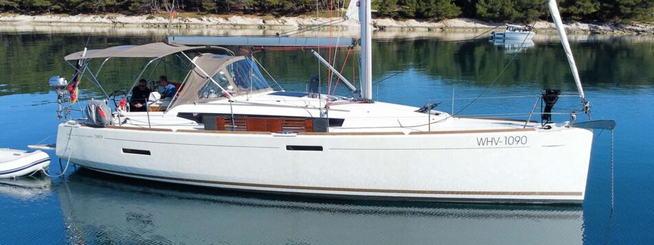 Seitenansicht der Segelyacht Sun Odyssey 389 „Tina" mit Bimini vor Anker in einer Bucht bei Pula – Yachtcharter Kroatien