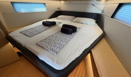 Gepflegte Bugkabine der Hanse 460 „Antares“ mit frisch bezogenem Doppelbett, dunklem Bettrahmen und gerollten Handtüchern – Yachtcharter Can Pastilla