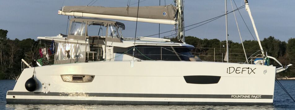 Backbord-Profil des Katamarans Lucia 40.3 „Idefix“ vor Anker in einer Bucht bei Rogoznica – Yachtcharter Kroatien