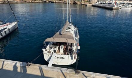 Bug der Segelyacht Sun Odyssey 440 „Carlotta“ am Liegeplatz, dahinter die Hafenstadt auf Mallorca – Yachtcharter Mallorca