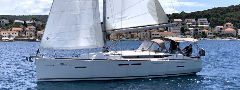 Die Segelyacht Sun Odyssey 419 „Espresso“ segelt mit Bimini und Crew am Steuer vor Rogoznica – Yachtcharter Kroatien