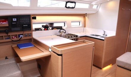 Großzügiger Kartentisch und offene Pantry im geräumigen Salon der Segelyacht Sun Odyssey 440 „Cassiopeia“ – Yachtcharter Ostsee