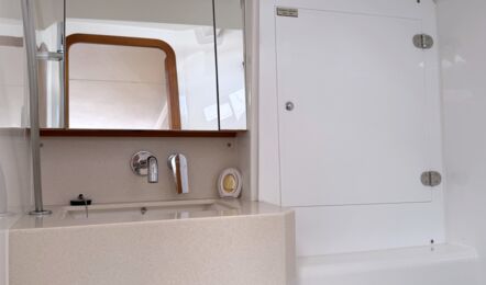 Helle Nasszelle auf der Steuerbordseite der Segelyacht Dufour 37 „Chiquitita“ mit WC, Spüle und Duschfunktion – Yachtcharter Ostsee