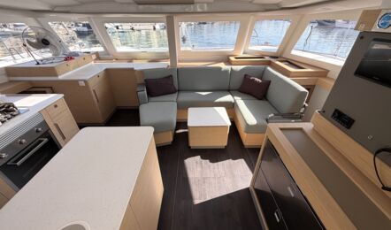 Heller Salon der Segelyacht FP44 „Hi iaka“ mit U-förmigem Sitzbereich, großer Pantry, viel Stauraum und Rundumblick durch große Fensterflächen – Yachtcharter Mallorca