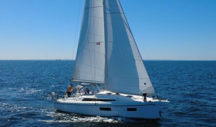 Ansicht der Steuerbordseite der Segelyacht Oceanis 34.1 „Fiete” mit gehissten Segeln auf offener See vor Heiligenhafen – Yachtcharter Ostsee