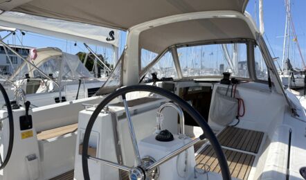 Blick ins Cockpit der Segelyacht Oceanis 38.1 „Nature“ mit Steuerstand auf der Steuerbordseite, Sprayhood, Targabügel und Bimini am Steg in Heiligenhafen – Yachtcharter Ostsee
