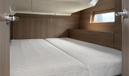 Achterkabine auf der Backbordseite der Segelyacht Oceanis 47 „Große Freiheit“ mit Doppelkoje und dunklem Holzausbau – Yachtcharter Ostsee