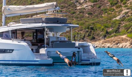 Gäste springen vom Heck eines FP 44 Katamarans ins türkisfarbene Wasser, Cockpit und Badeplattform (Werftbild) – Yachtcharter Mallorca