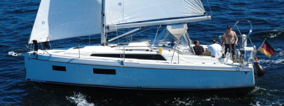 Ansicht der Backseite der Segelyacht Oceanis 34.1 „Fiete” mit gehissten Segeln auf offener See vor Heiligenhafen – Yachtcharter Ostsee