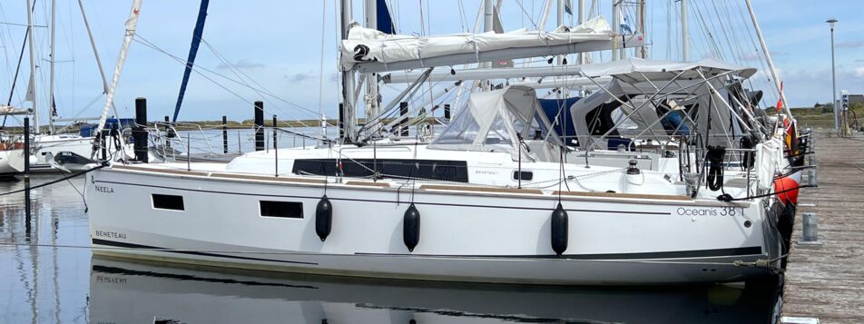 Backbord-Seitenansicht der Segelyacht Oceanis 38.1 „Neela“ mit Bimini am Steg in Heiligenhafen – Yachtcharter Ostsee
