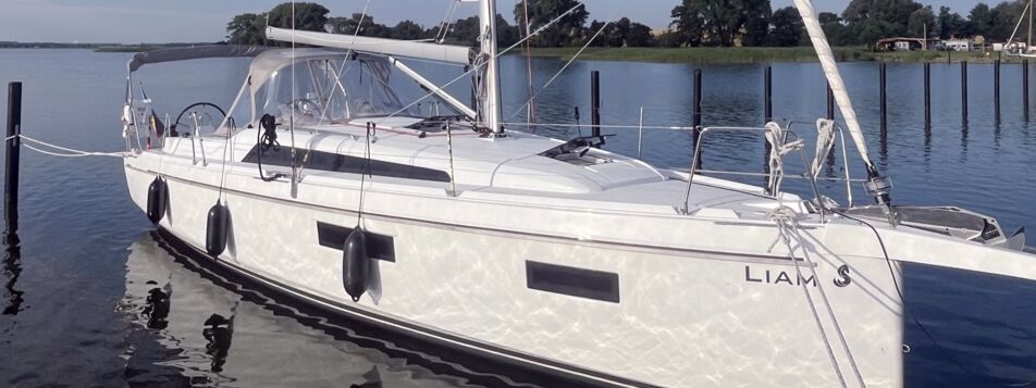 Steuerbord-Seitenansicht der Segelyacht Oceanis 34.1.2 „Liam“ mit Namenszug am Steg in Heiligenhafen – Yachtcharter Ostsee