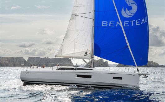 Steuerbordansicht einer Oceanis 37.1 unter Segeln entlang einer Küste mit Klippen im Hintergrund (Werftbild) – Yachtcharter Ostsee