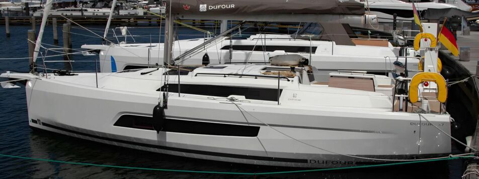 Seitenansicht der Segelyacht Dufour 37 „Chiquitita“ am Steg mit Persenning über dem Großbaum – Yachtcharter Ostsee, Heiligenhafen