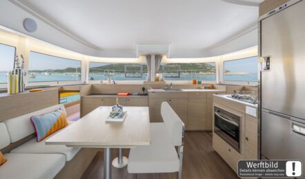 Heller Salon einer Lagoon 38 mit hellem Holzausbau, offener Pantry und großem Kühlschrank (Werftbild) – Yachtcharter Mallorca