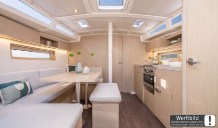 Heller Salon einer Oceanis 37.1 mit hellem Holzausbau, offener Pantry und Blick nach vorn (Werftbild) – Yachtcharter Ostsee