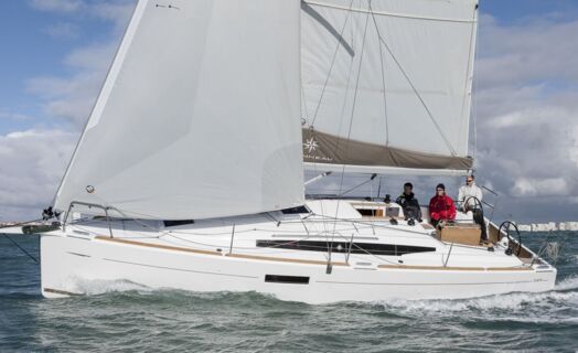 Eine Sun Odyssey 349 unter vollen Segeln in Seitenansicht mit Crew im Cockpit – Yachtcharter Ostsee ab Flensburg (Werftbild)