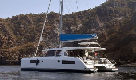 Seitenprofil der „Lady Mara“ mit hohem Mast, vor Anker an einer Bergküste – Yachtcharter Mallorca