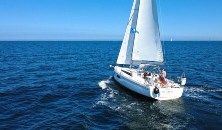 Heckansicht der Segelyacht Oceanis 34.1 „Fiete“ mit gehissten Segeln auf offener See vor Heiligenhafen – Yachtcharter Ostsee