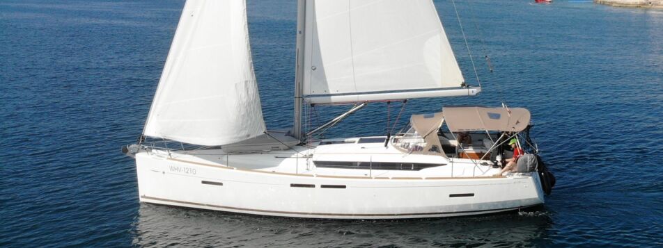 Seitenansicht der Segelyacht Sun Odyssey 419 „Mira" unter vollen Segeln mit Bimini in einer Bucht bei Pula – Yachtcharter Kroatien