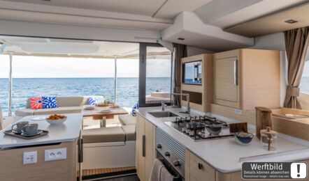 Pantry eines FP 44 Katamarans mit Spüle und Gasherd, offene Schiebetür zum Cockpit mit Meerblick (Werftbild) – Yachtcharter Mallorca