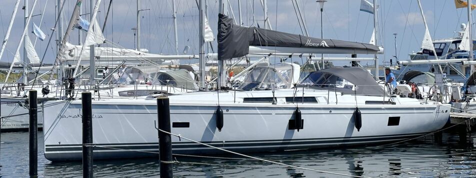 Weiße Segelyacht Hanse 458.3 „Namaka Elua“ längsseits am Steg mit Hanse-Persenning – Yachtcharter Mallorca