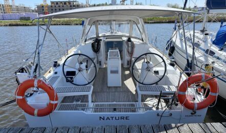 Blick ins Cockpit der Segelyacht Oceanis 38.1 „Nature“ vom Heck mit zwei Steuerständen, Teakboden, Bimini und Sprayhood am Steg in Greifswald – Yachtcharter Ostsee