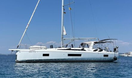 Backbordansicht der Segelyacht Oceanis 51.1.3 „Marny“ vor Anker in azurblauem Wasser mit Küste im Hintergrund – Yachtcharter Kroatien