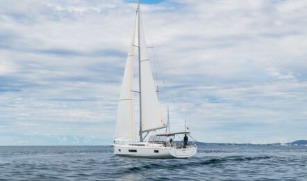 Heckansicht der segelnden Oceanis 51.1 „Flipper“ mit Crew im Cockpit auf See vor Mallorca – Yachtcharter Mallorca