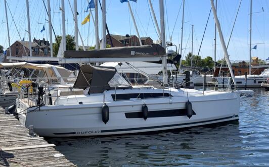 Steuerbordansicht der Segelyacht Dufour 37 „Chiquitita“ mit Sprayhood am Steg in Heiligenhafen – Yachtcharter Ostsee