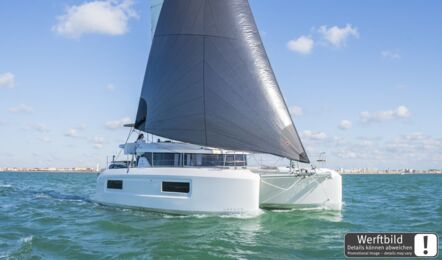 Steuerbordansicht einer Lagoon 38 vom Bug unter Segeln vor der Küste bei leichtem Wellengang (Werftbild) – Yachtcharter Mallorca