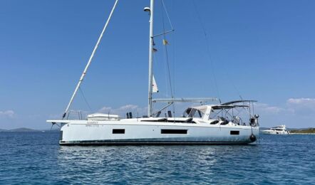 Backbordansicht der Segelyacht Oceanis 51.1.3 „Marny“ vor Anker in azurblauem Wasser mit Küste im Hintergrund – Yachtcharter Kroatien