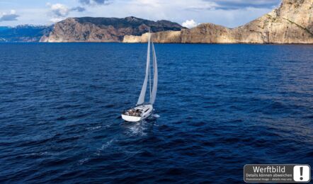 Heckansicht einer Sun Odyssey 455 aus der Vogelperspektive unter Segeln auf offenem Meer mit bergiger Küste im Hintergrund (Werftbild) – Yachtcharter Kroatien
