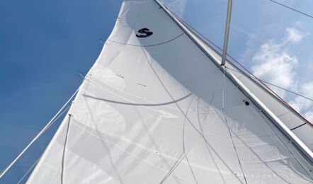 Blick nach oben in das gesetzte Großsegel der Segelyacht Oceanis 30.1.2 „Lundi“ vor blauem Himmel – Yachtcharter Ostsee