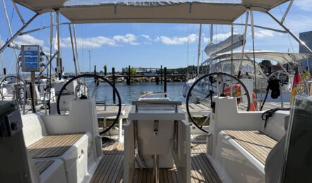 Blick aus dem Niedergang nach achtern ins Cockpit der Segelyacht Oceanis 38.1 „Nature“ mit zwei Steuerständen, Bimini und Teakboden am Steg in Heiligenhafen – Yachtcharter Ostsee