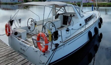 Steuerbordansicht des Heckbereichs der Segelyacht Oceanis 38.1 „Nature“ mit Bimini und Sprayhood am Steg in Greifswald – Yachtcharter Ostsee