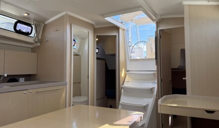 Blick vom Salontisch durch den Salon der Segelyacht Oceanis 38.1 „Nature“ zur Achterkabine Steuerbord und zum Badezimmer Steuerbord mit WC und Spüle – Yachtcharter Ostsee