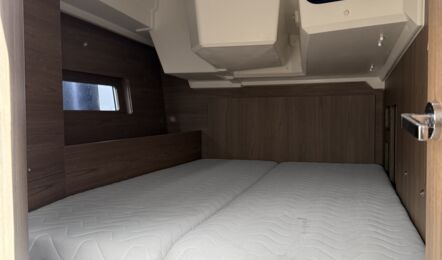 Achterkabine auf der Steuerbordseite der Segelyacht Oceanis 47 „Große Freiheit“ mit Doppelkoje und dunklem Holzausbau – Yachtcharter Ostsee