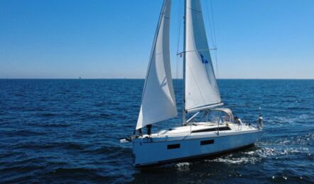 Ansicht der Backseite der Segelyacht Oceanis 34.1 „Fiete” mit gehissten Segeln auf offener See vor Heiligenhafen – Yachtcharter Ostsee