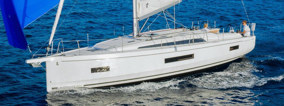 Eine Segelyacht Oceanis 40.1.4 mit weißem Rumpf segelt unter blauem Gennaker auf dem Meer – Yachtcharter Mallorca