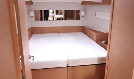 Blick aus dem Salon in die Bugkabine der Segelyacht Sun Odyssey 440 „Cassiopeia“ mit hellen Matratzen und geräumiger Doppelkoje – Yachtcharter Ostsee