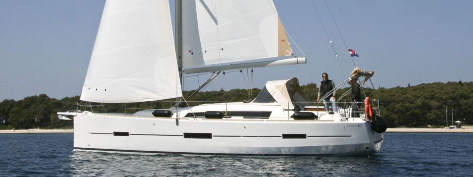 Seitenansicht der Segelyacht Dufour 412 GL „Stella“ unter vollen Segeln vor bewaldeter Küste bei Pula – Yachtcharter Kroatien