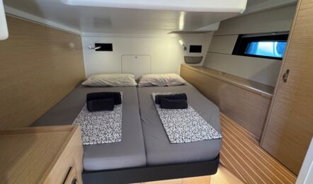 Gepflegte Bugkabine der Hanse 460 „Antares" mit frisch bezogenem Doppelbett, Handtüchern und LED-Leselampen – Yachtcharter Can Pastilla