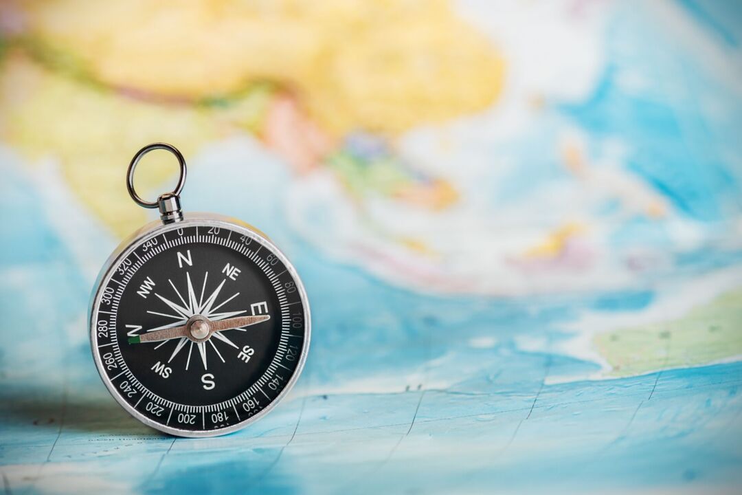 Kompass auf blauer Weltkarte – NavimetriX App für Wetter, Navigation und Segelrouting