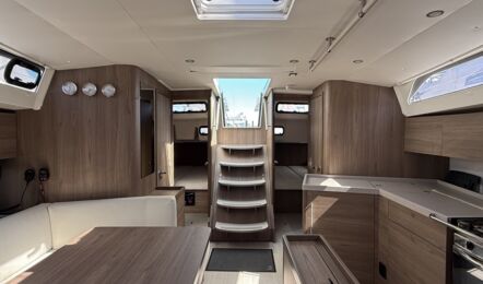 Salon der Segelyacht Oceanis 47 „Große Freiheit“ mit Blick nach achtern, dunklem Holzausbau und offener Pantry – Yachtcharter Ostsee