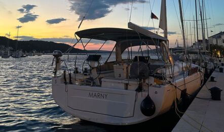 Heckansicht der Segelyacht Oceanis 51.1.3 „Marny“ an einer Kaimauer an der Promenade einer kroatischen Hafenstadt in abendlicher Atmosphäre – Yachtcharter Kroatien