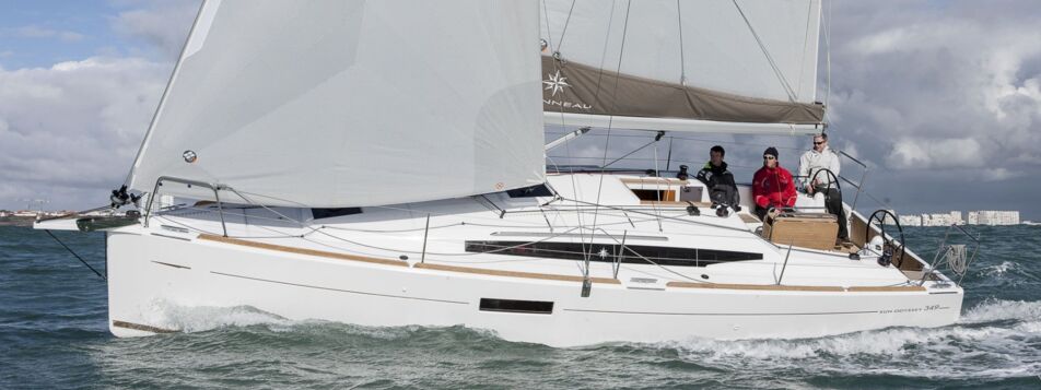 Eine Sun Odyssey 349 unter vollen Segeln in Seitenansicht mit Crew im Cockpit – Yachtcharter Ostsee ab Flensburg (Werftbild)